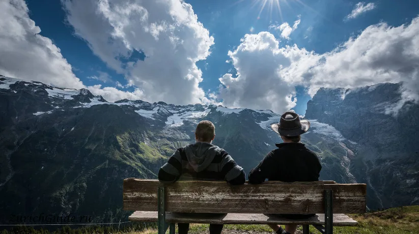 Two people on a bench looking at the mountains above Engelberg